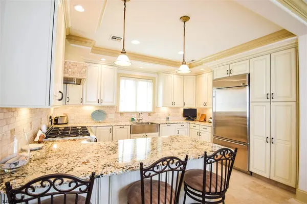 a kitchen with stainless steel appliances granite countertop a stove a sink a dining table and chairs