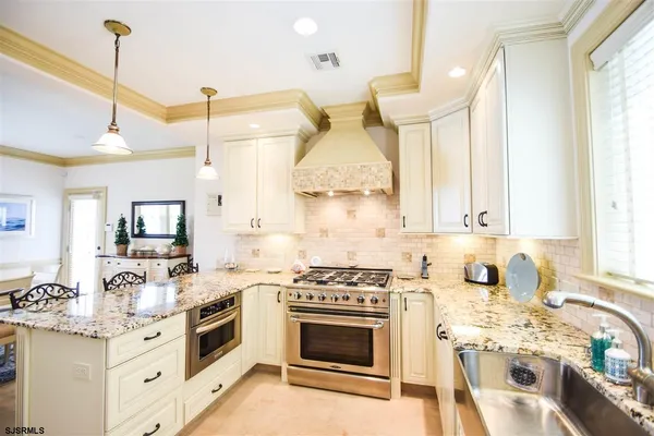 a kitchen with a stove a sink and a wooden floor