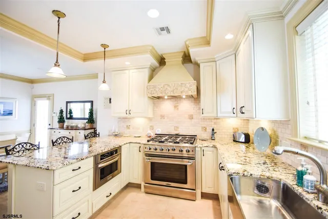 a kitchen with a stove a sink and a wooden floor