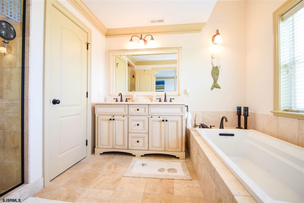 11 South 31st Avenue Longport, NJ 08403 - Photo 17 of 25 a spacious bathroom with a double vanity sink a mirror and a bathtub