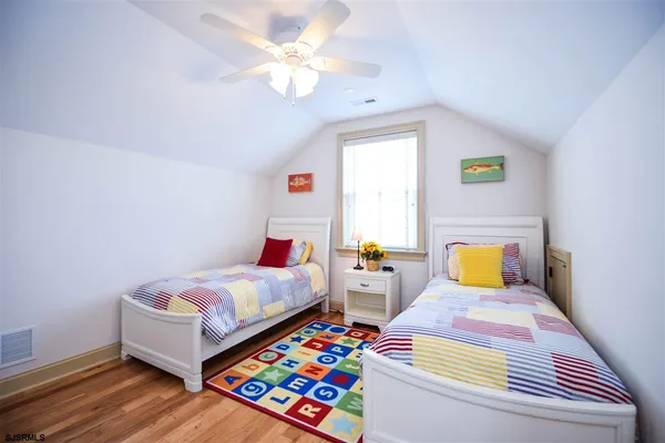 a bedroom with 2 bed and a window