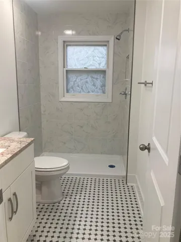 a bathroom with a toilet a shower a toilet and a shower