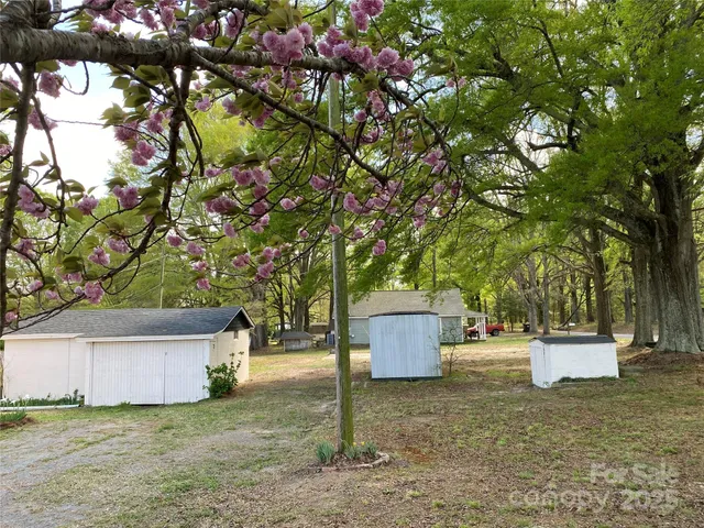 a backyard of a house with barbeque oven and tree