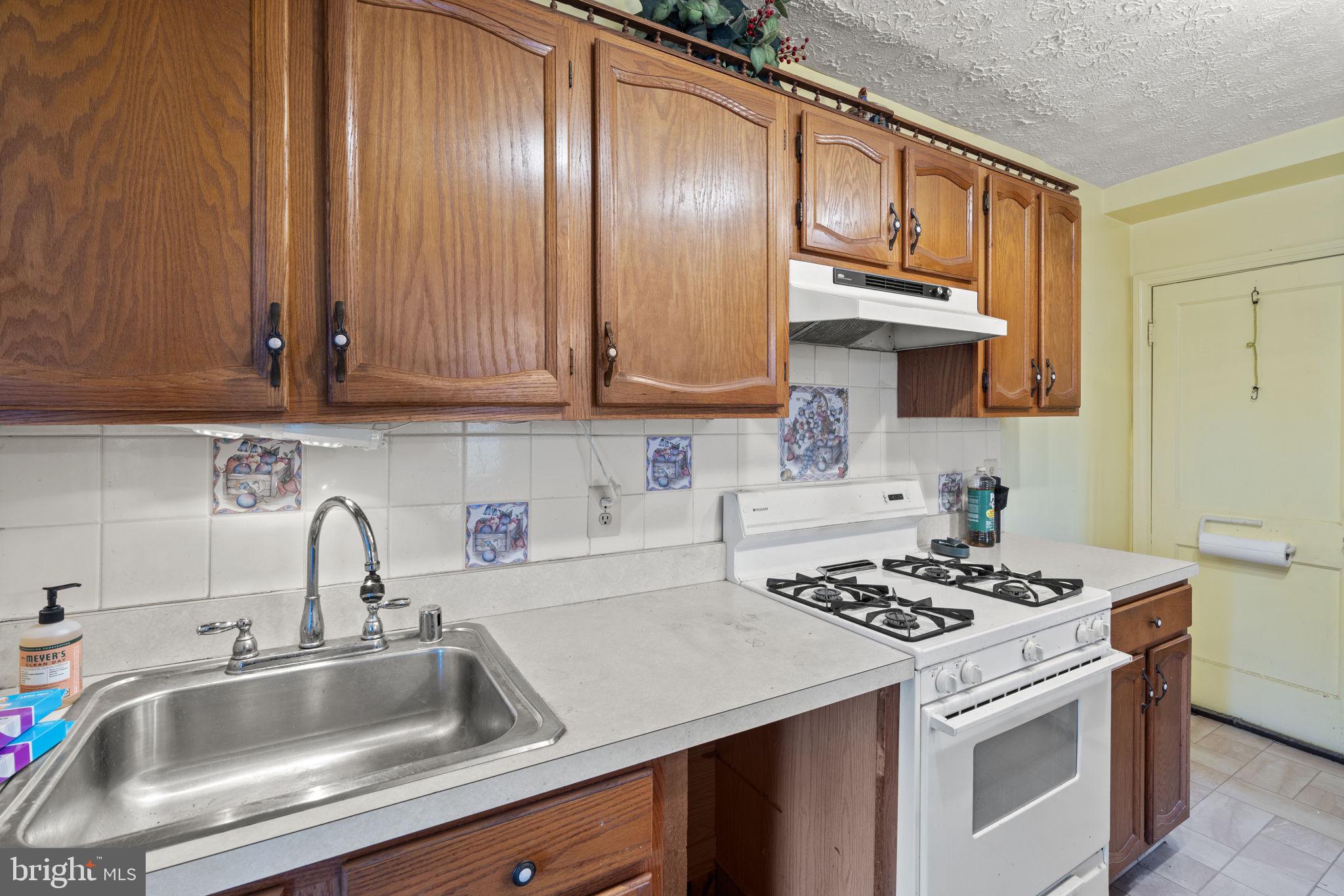 1870 Yakona Road Baltimore, MD 21234 - Photo 12 of 31 a kitchen with granite countertop a sink stainless steel appliances wooden cabinets and a counter top space