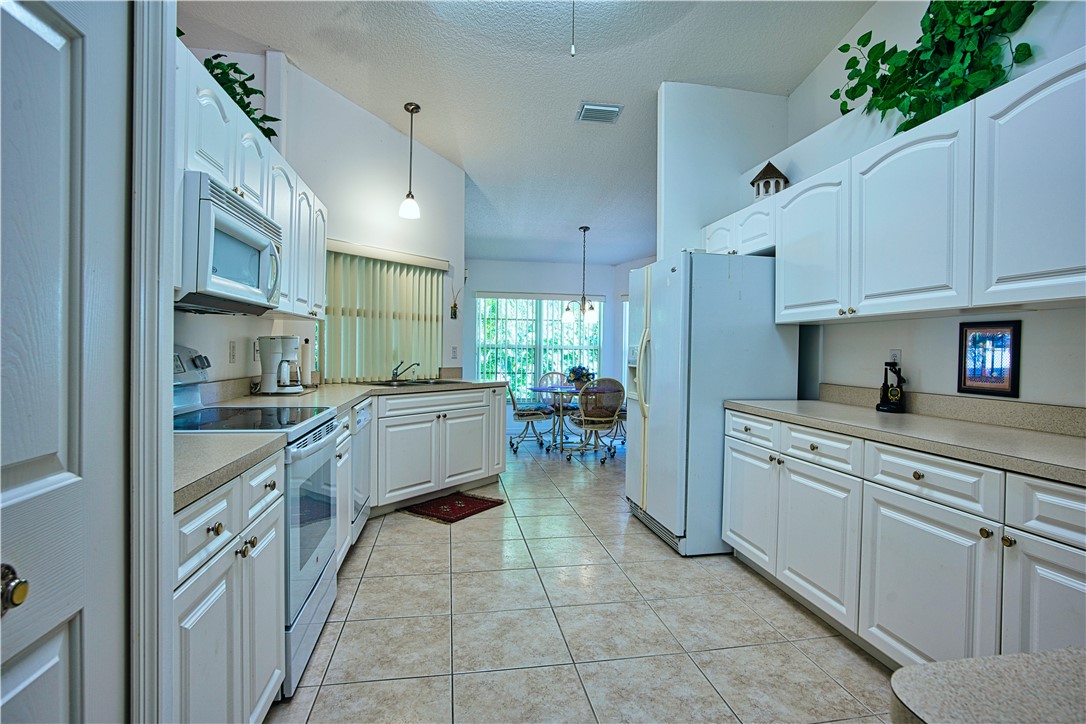 173 Easy Street Sebastian, FL 32958 - Photo 13 of 35 a kitchen with cabinets and chairs