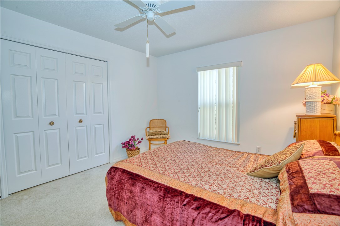 173 Easy Street Sebastian, FL 32958 - Photo 23 of 35 a bedroom with a bed and a chandelier