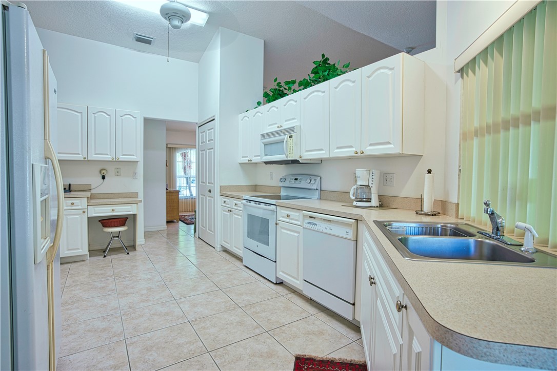 173 Easy Street Sebastian, FL 32958 - Photo 9 of 35 a kitchen with cabinets appliances a sink and a counter top space