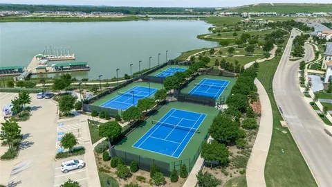 an aerial view of residential houses with outdoor space and lake view