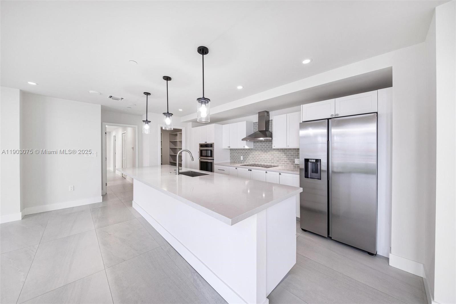 555 Northeast 34th Street, Unit PH3 Miami, FL 33137 - Photo 6 of 51 a large white kitchen with cabinets and stainless steel appliances
