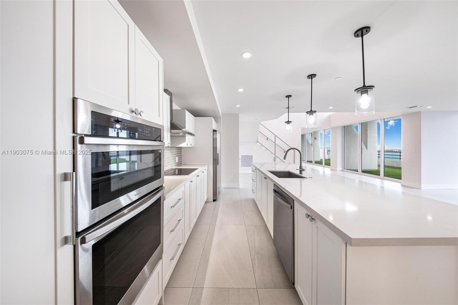 555 Northeast 34th Street, Unit PH3 Miami, FL 33137 - Photo 7 of 51 a large kitchen with stainless steel appliances kitchen island granite countertop a large counter top and a stove