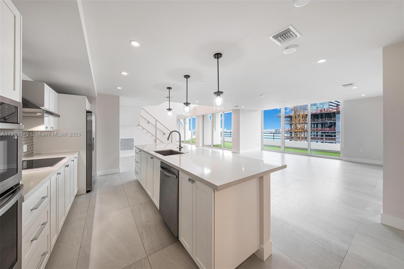 555 Northeast 34th Street, Unit PH3 Miami, FL 33137 - Photo 8 of 51 a large kitchen with stainless steel appliances kitchen island granite countertop a large counter top and a stove