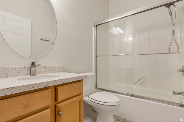 1092 Tithing Ridge Drive Riverton, UT 84065 - Photo 14 of 25 Guest Bathroom featuring a light wood vanity, speckled white countertop with integrated sink, and a brushed nickel faucet