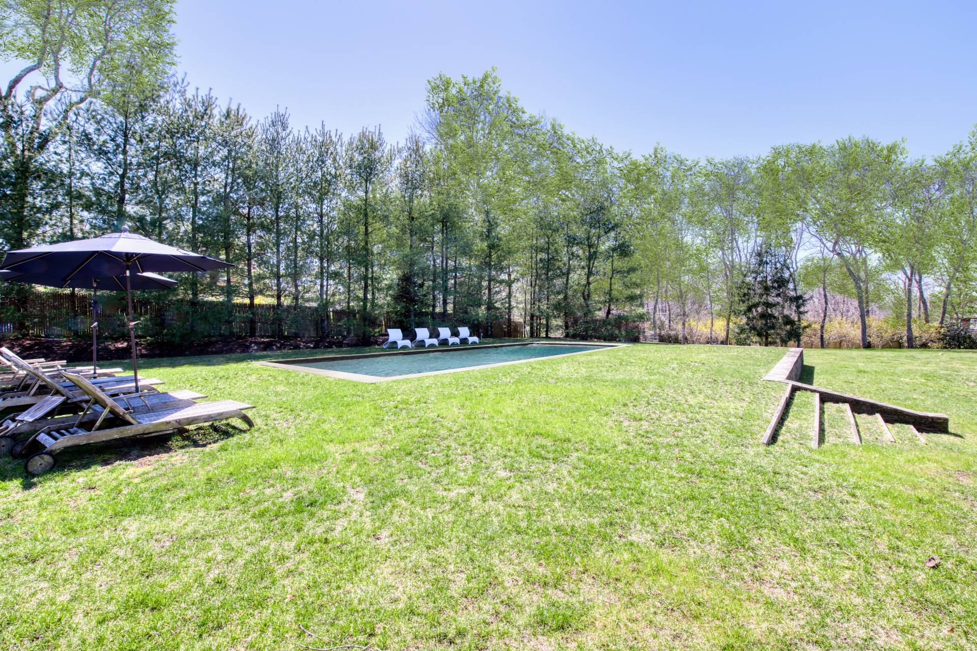 Undisclosed Address Sag Harbor, NY 11963 - Photo 4 of 23 a view of a backyard with table and chairs under an umbrella