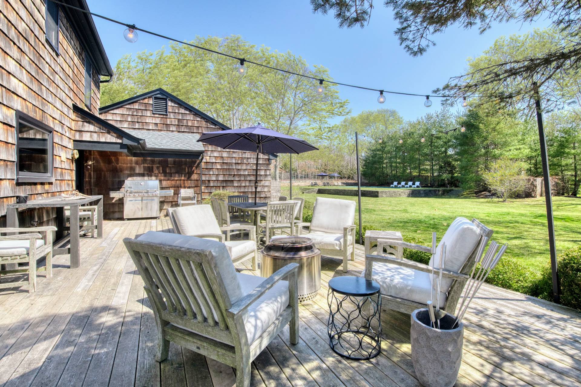 Undisclosed Address Sag Harbor, NY 11963 - Photo 5 of 23 a view of a patio with couches table and chairs under an umbrella