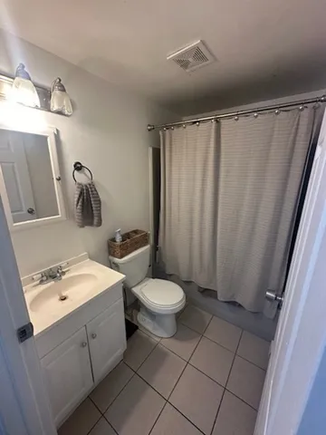 a bathroom with a sink a toilet and shower curtain