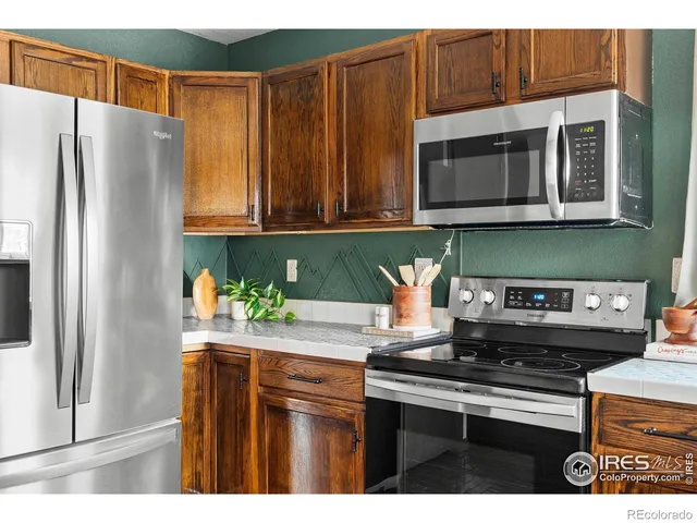 a kitchen with stainless steel appliances granite countertop a refrigerator and a stove top oven