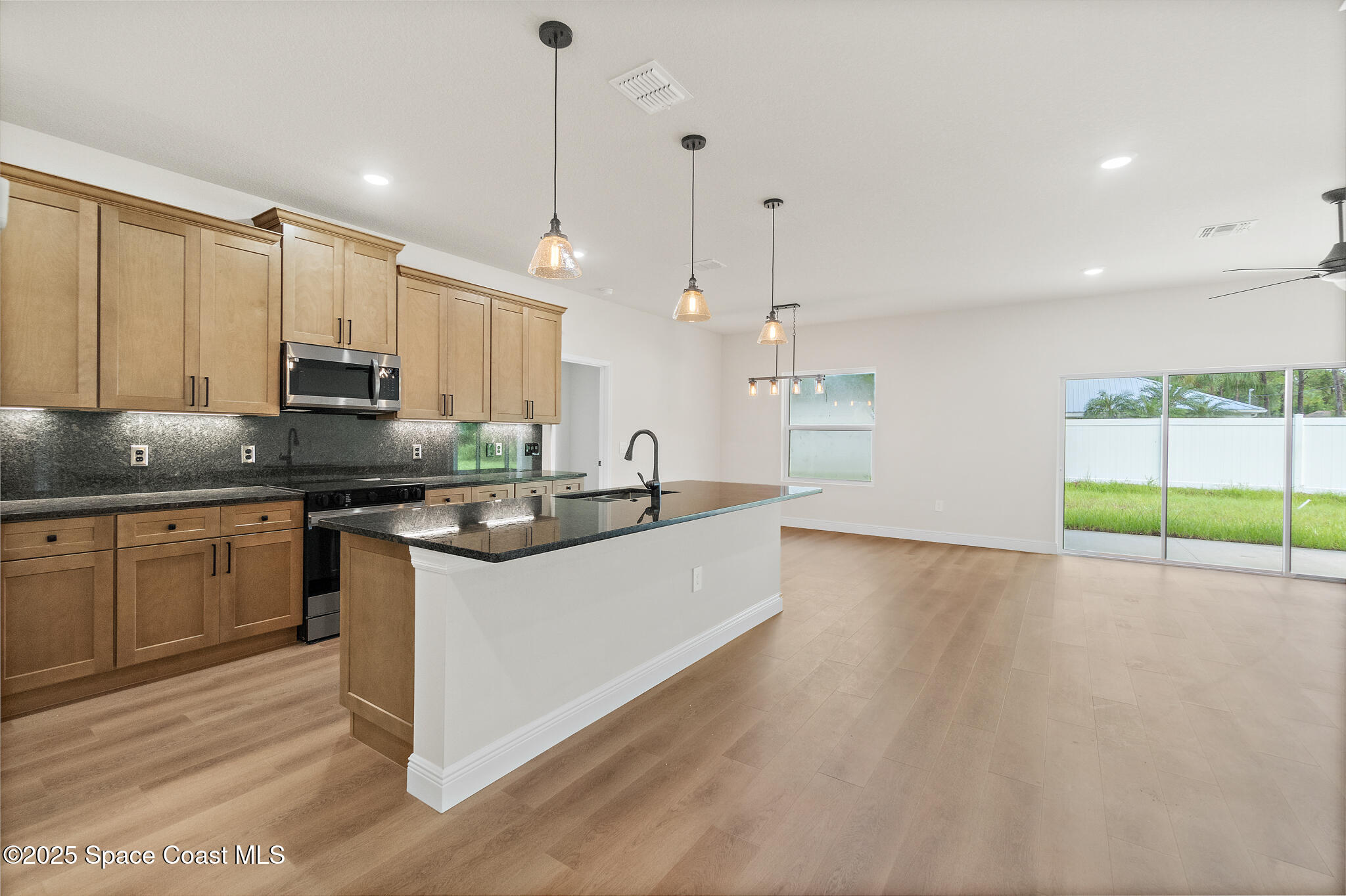 1541 Madison Road Northwest Palm Bay, FL 32907 - Photo 12 of 62 a kitchen with stainless steel appliances granite countertop a sink a stove and a wooden floors