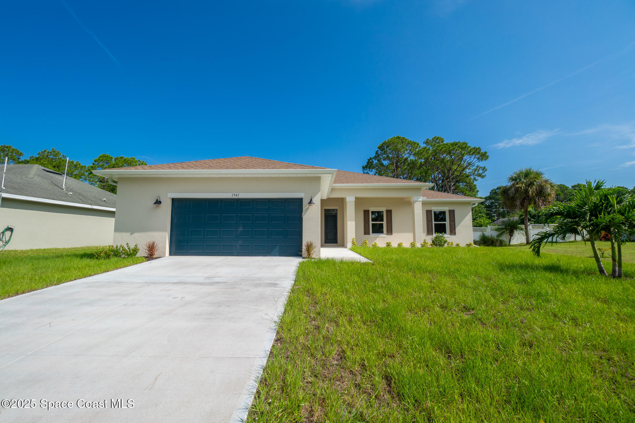 1541 Madison Road Northwest Palm Bay, FL 32907 - Photo 2 of 62 a front view of a house with a yard and garage