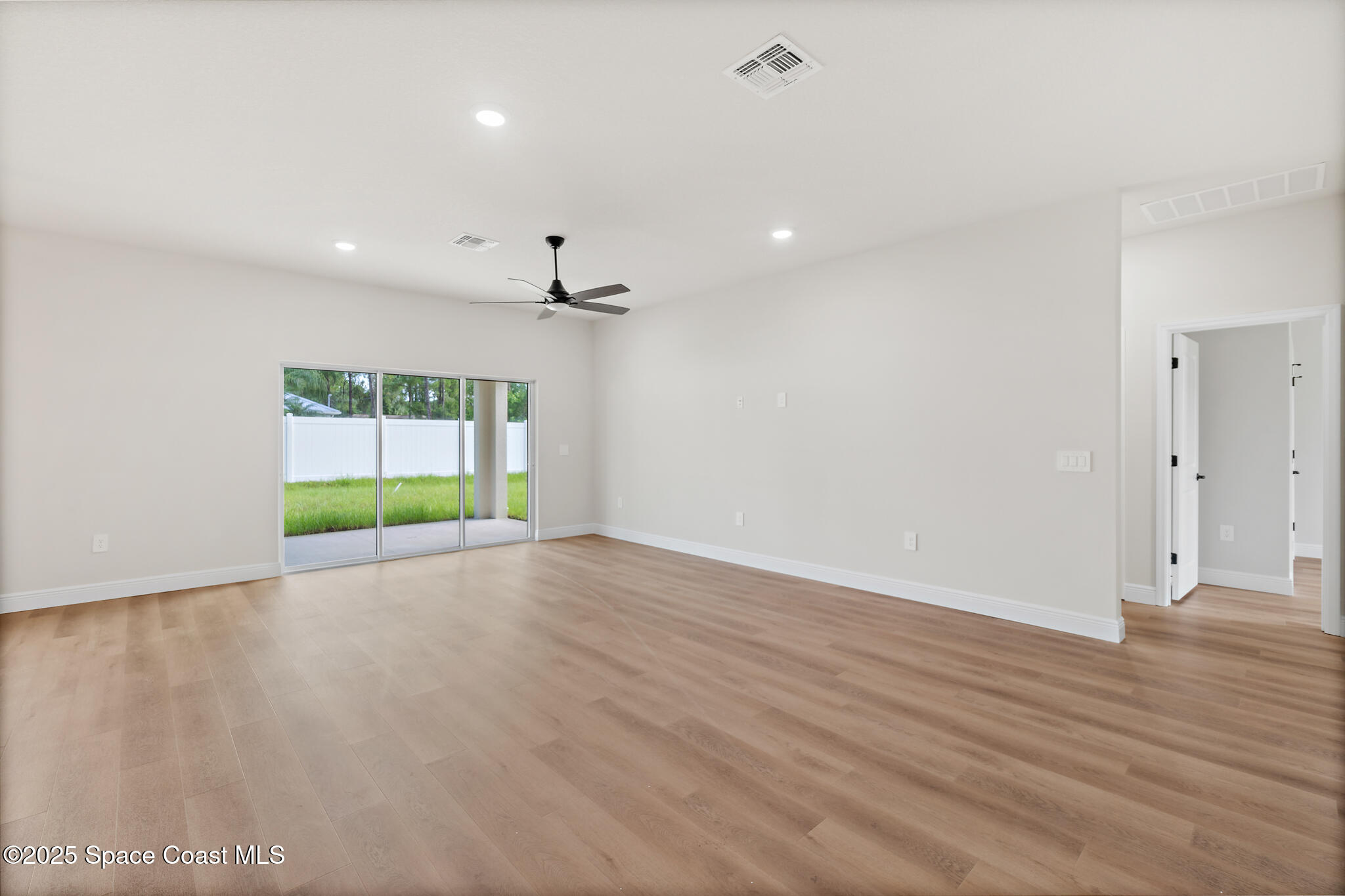 1541 Madison Road Northwest Palm Bay, FL 32907 - Photo 24 of 62 an empty room with wooden floor and natural light