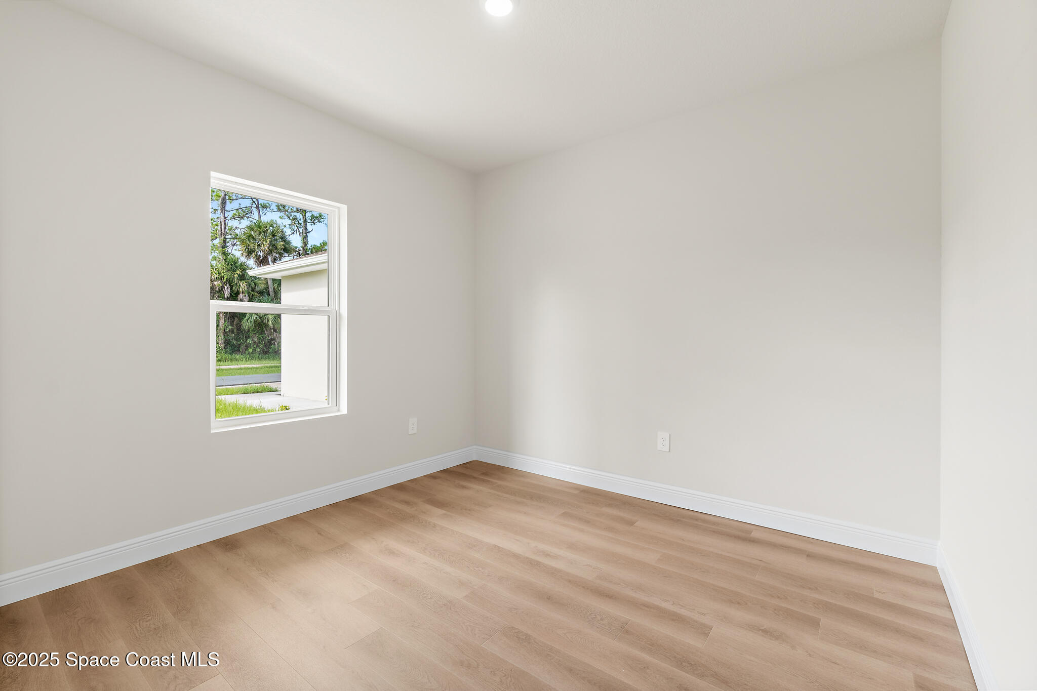 1541 Madison Road Northwest Palm Bay, FL 32907 - Photo 32 of 62 an empty room with wooden floor and windows