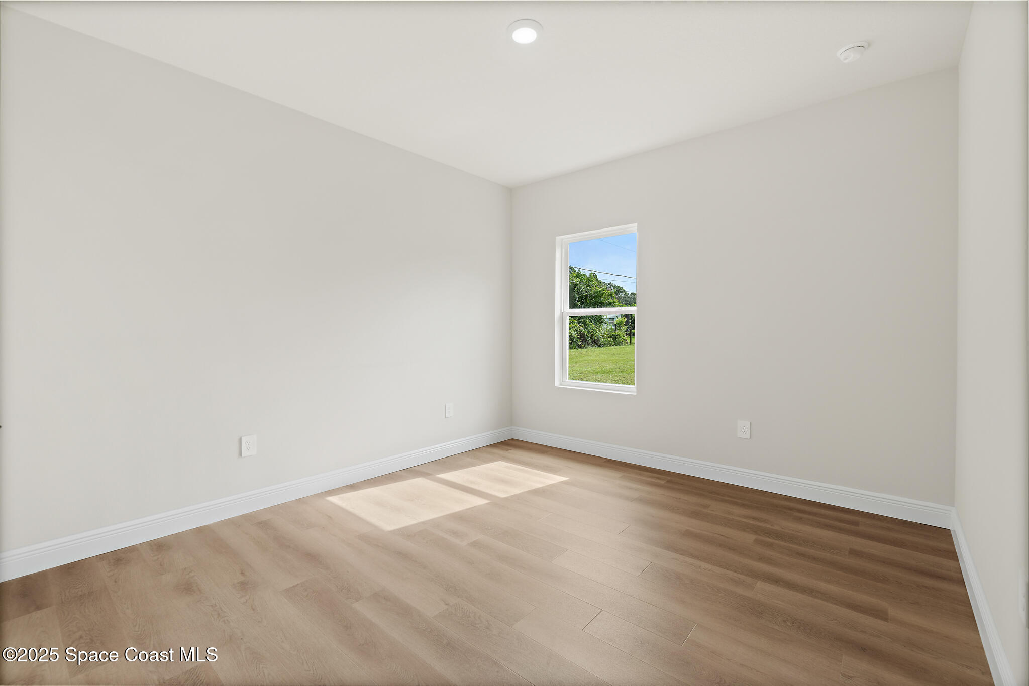 1541 Madison Road Northwest Palm Bay, FL 32907 - Photo 38 of 62 an empty room with wooden floor and windows