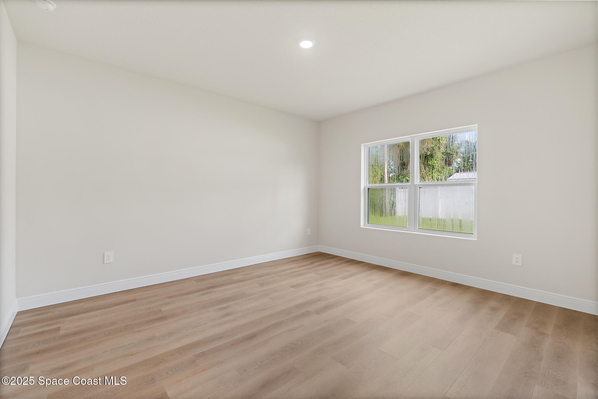 1541 Madison Road Northwest Palm Bay, FL 32907 - Photo 40 of 62 an empty room with wooden floor and windows