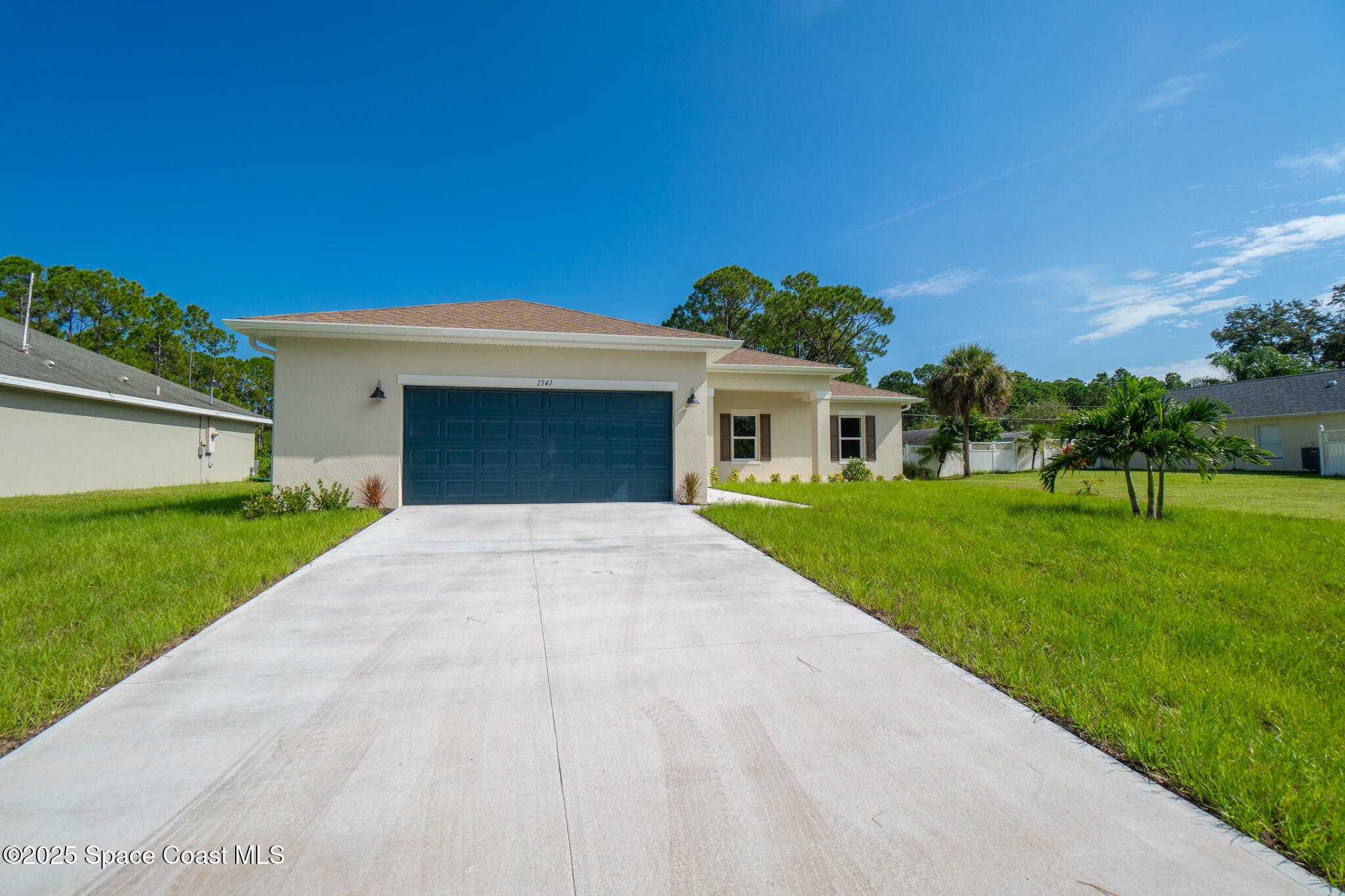 1541 Madison Road Northwest Palm Bay, FL 32907 - Photo 46 of 62 a front view of a house with a yard and garage