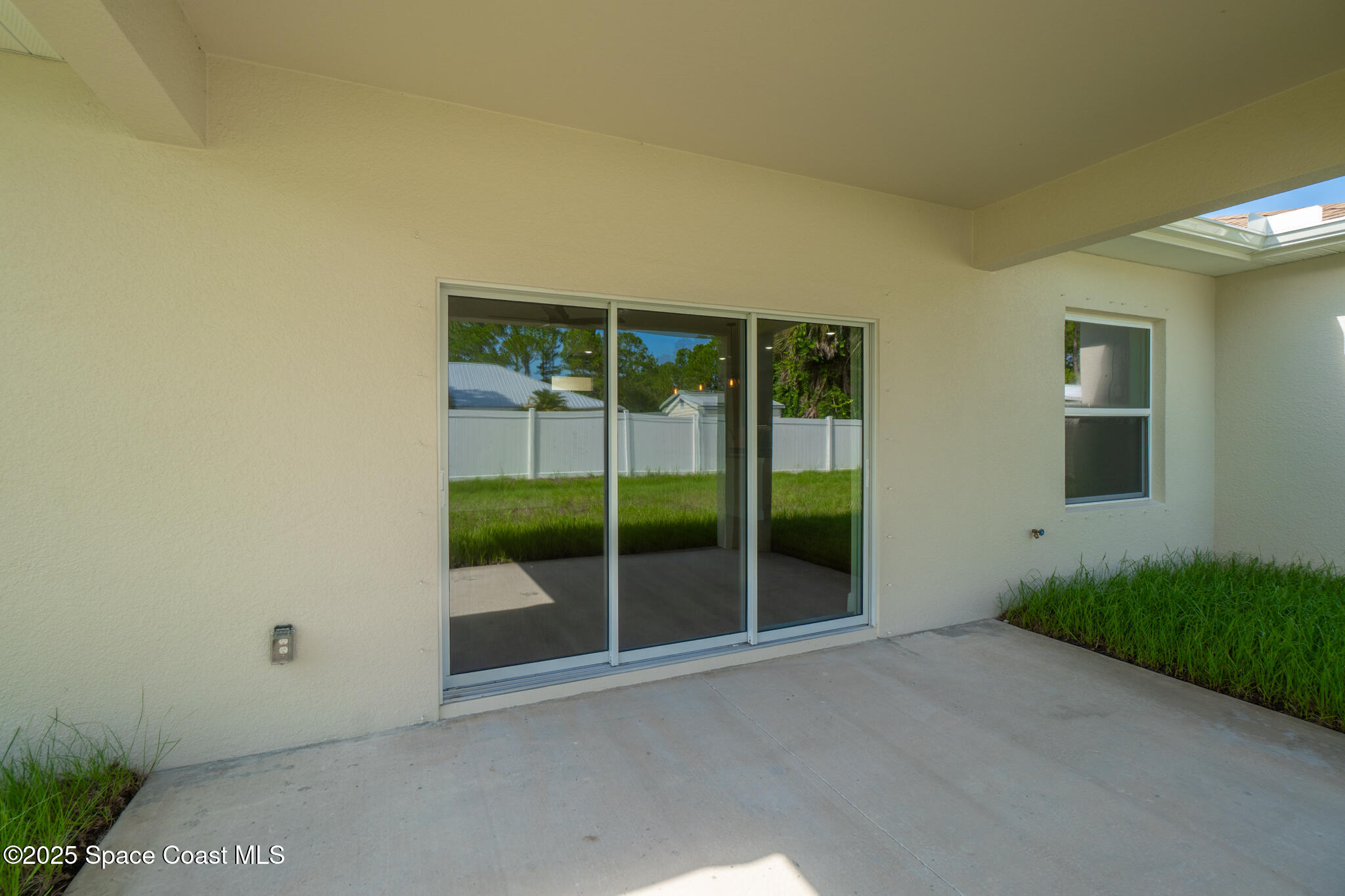 1541 Madison Road Northwest Palm Bay, FL 32907 - Photo 54 of 62 an empty room with sliding glass door and garden space