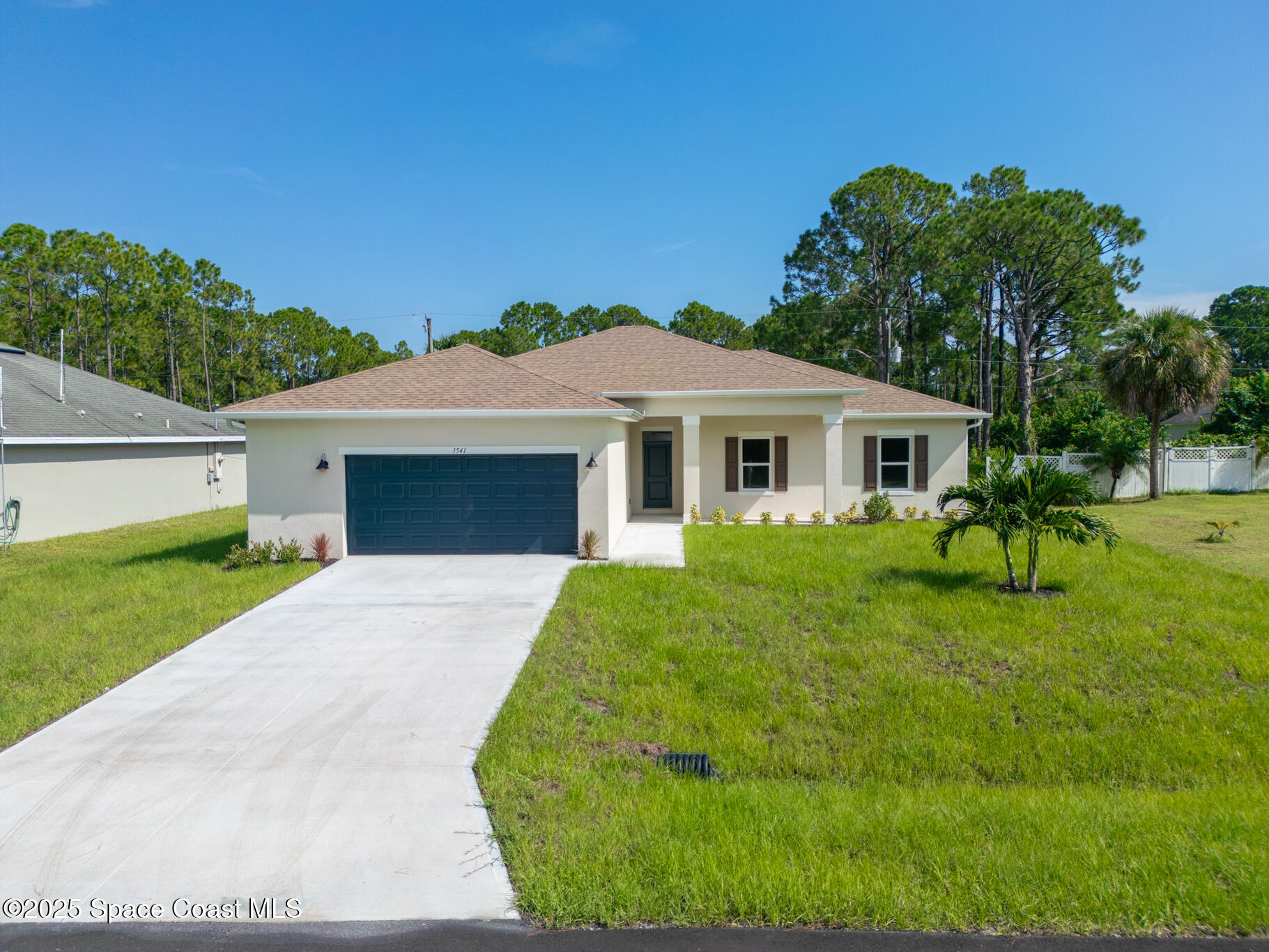 1541 Madison Road Northwest Palm Bay, FL 32907 - Photo 8 of 62 a front view of a house with a yard and trees