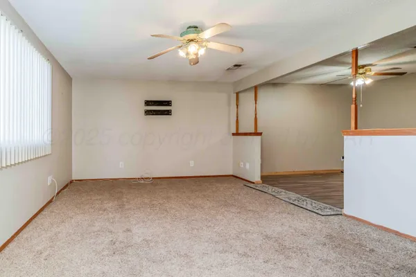 wooden floor in an empty room and a chandelier fan