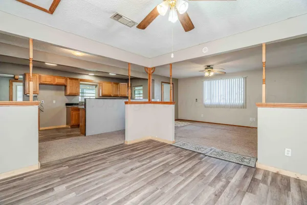 a kitchen with stainless steel appliances granite countertop wooden cabinets a sink and dishwasher a oven with wooden floors