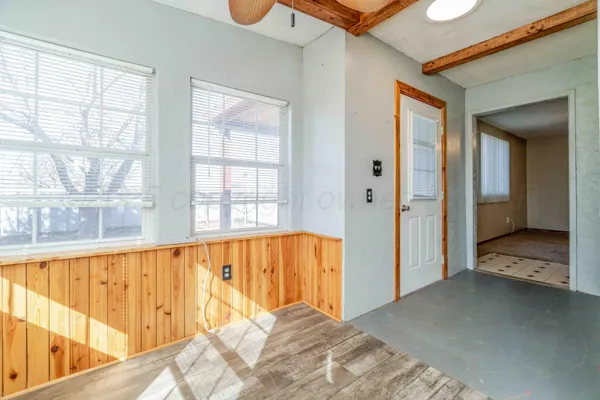 a view of a hallway with wooden floor and a living room