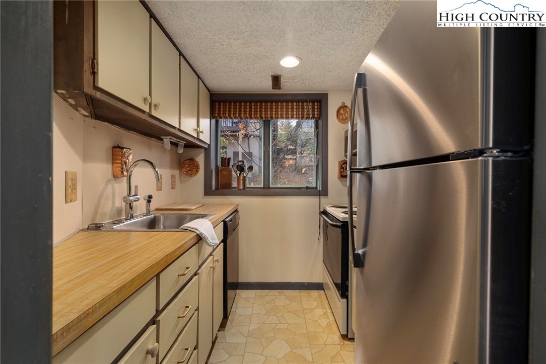 220 Northridge Road, Unit D15 Beech Mountain, NC 28604 - Photo 13 of 47 a kitchen with stainless steel appliances a refrigerator and a sink