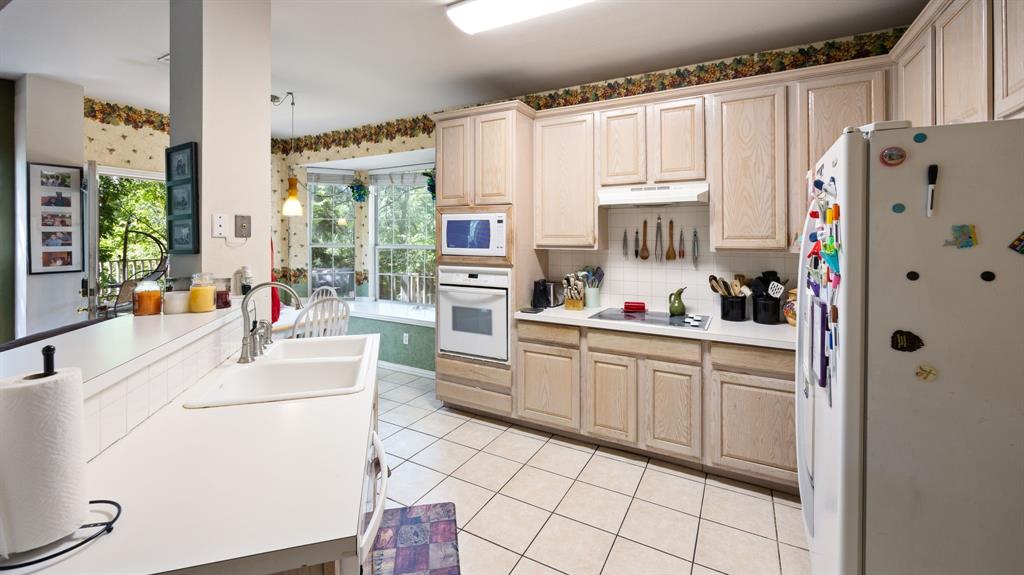 1508 Valley Creek Road Denton, TX 76205 - Photo 16 of 33 a kitchen with white cabinets and white appliances