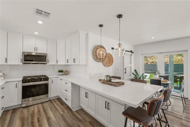 a kitchen with a sink a stove a microwave and cabinets