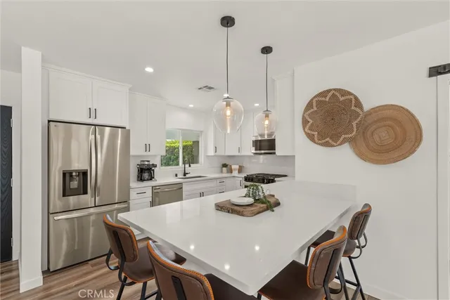 a kitchen with kitchen island granite countertop a sink a stove top oven and cabinetry