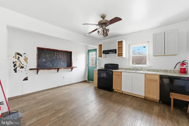 a kitchen with a refrigerator and white cabinets