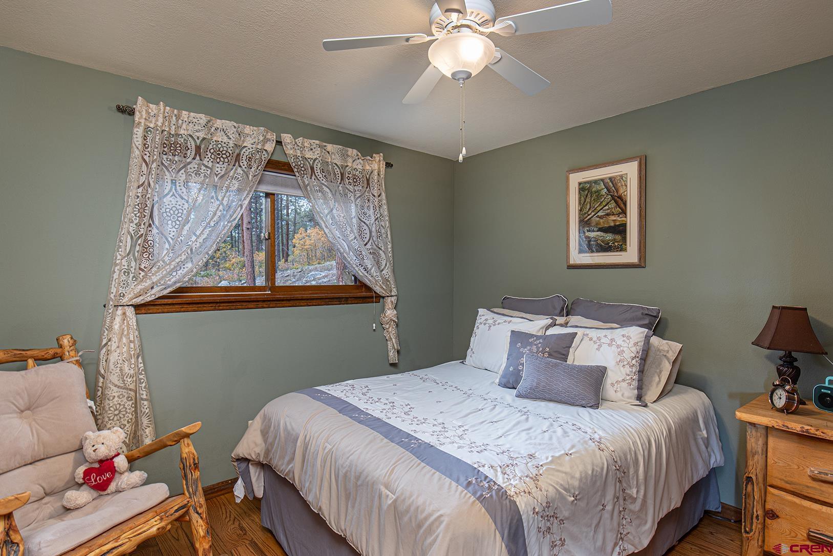 375 Nusbaum Road Durango, CO 81301 - Photo 19 of 33 a bedroom with a bed and a chandelier