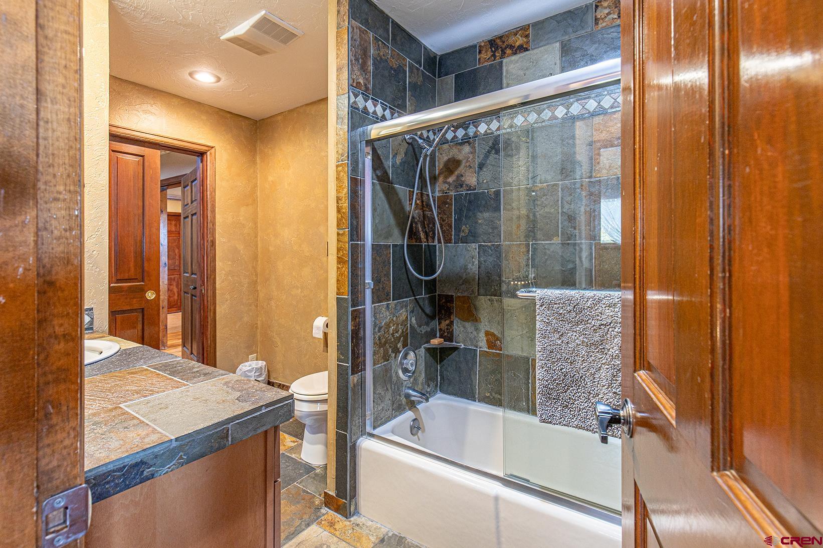375 Nusbaum Road Durango, CO 81301 - Photo 20 of 33 a bathroom with a granite countertop sink a mirror and shower