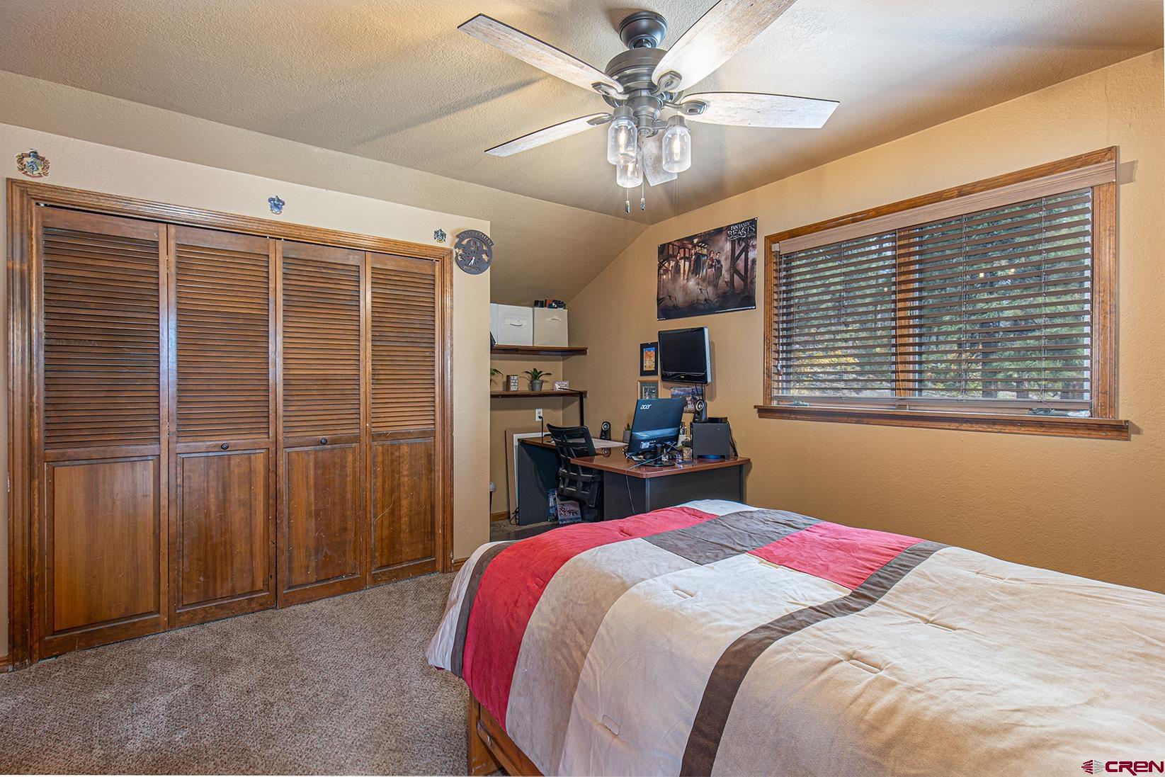 375 Nusbaum Road Durango, CO 81301 - Photo 22 of 33 a bedroom with a large bed and a chandelier