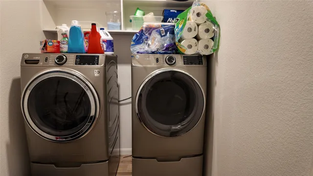 a kitchen with stainless steel appliances a dining table chairs refrigerator and sink