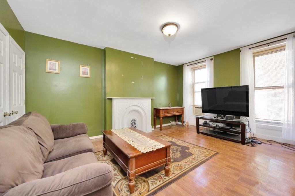 964 Gates Avenue Brooklyn, NY 11221 - Photo 15 of 25 a living room with furniture and a flat screen tv