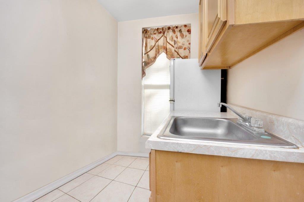 964 Gates Avenue Brooklyn, NY 11221 - Photo 17 of 25 a kitchen with a sink and a mirror