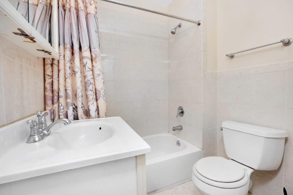 964 Gates Avenue Brooklyn, NY 11221 - Photo 19 of 25 a bathroom with a sink a toilet and a bathtub