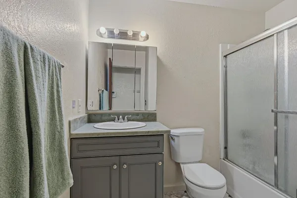 a bathroom with a sink a toilet and shower