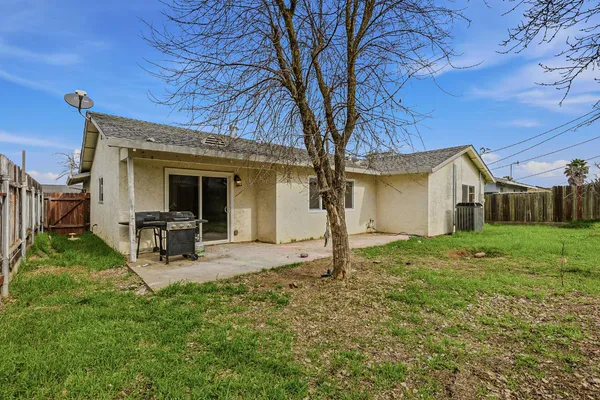a view of a house with backyard and a tree