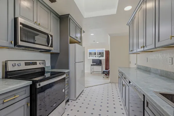 a kitchen with stainless steel appliances a stove a sink and a microwave
