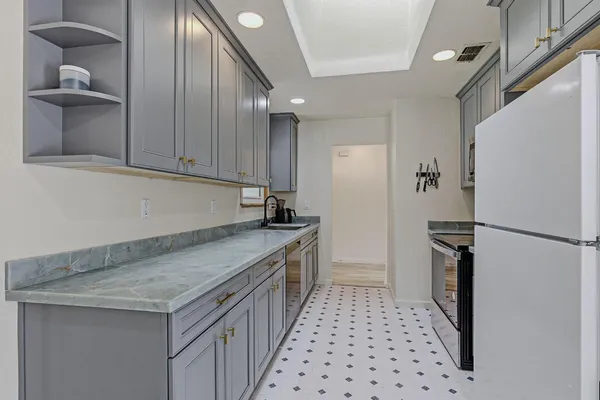 a kitchen with granite countertop a sink and a refrigerator
