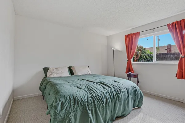 a bed sitting in a bedroom next to a window