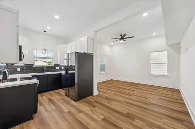 a kitchen with a refrigerator sink and cabinets